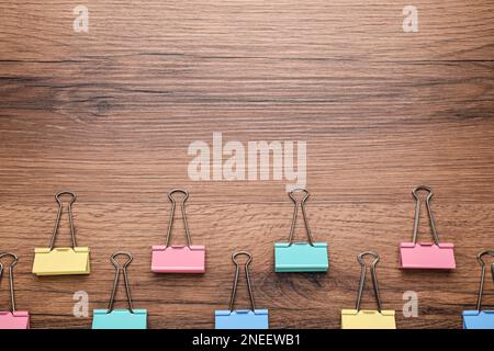 Bindemittel klemmt auf Holzhintergrund, flach verlegt. Platz für Text Stockfoto