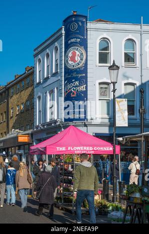 Leute an einem sonnigen Tag, Portobello Road. Farbenfrohe Fassade des Distillery Hotels, Bar und Restaurant im Hintergrund. London, England, Großbritannien Stockfoto