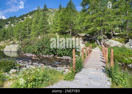 Die Fußgängerbrücke in der Landschaft am Lago d Arpy See. Stockfoto