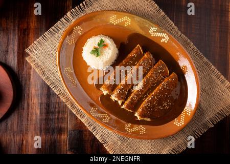 Hühnerenmoladas. Auch bekannt als Mole poblano enchiladas, sind sie ein typisches mexikanisches Gericht, das in Mexiko und dem Rest der Welt sehr beliebt ist. Stockfoto