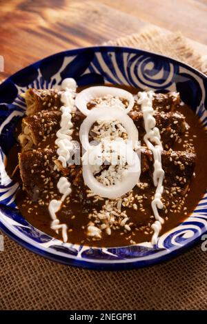 Hühnerenmoladas. Auch bekannt als Mole poblano enchiladas, sind sie ein typisches mexikanisches Gericht, das in Mexiko und dem Rest der Welt sehr beliebt ist. Stockfoto