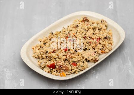 Couscous mit Gemüse in einem Gericht auf grauer Keramik Stockfoto