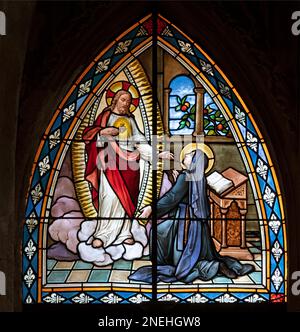 BIELLA, ITALIEN - 15. JULI 2022: Die Erscheinung des Herzens Jesus auf St. Theresa von Avila im Buntglas des Doms von 19. Cent. Stockfoto