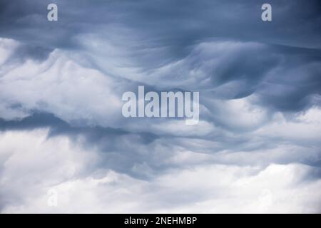 Spektakuläre Wolken des Undulatus Asperatus mit dunkelblauen Texturen und welligen Wellen und Lichtwellen, die neueste und seltene Wolkenformation. Stockfoto