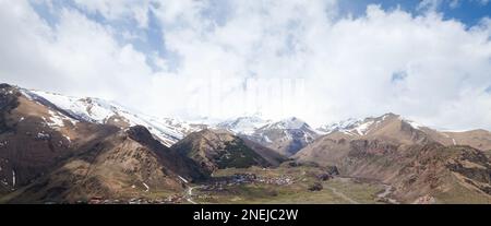 Georgianische Berglandschaft mit Kaukasus und Stepantsminda an einem sonnigen Tag. Panoramafoto Stockfoto