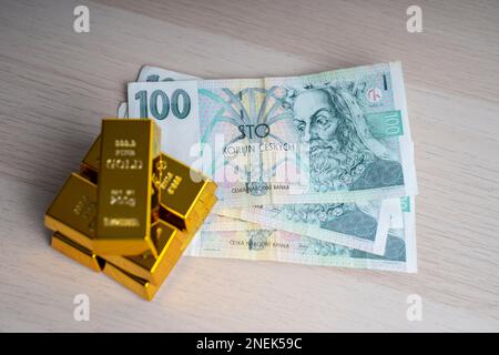 Tschechische Republik 100-korun-Papierbanknote. Tschechische Münzen und Goldbarren. Stockfoto