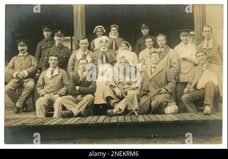 Original WW1 Postkarte mit britischen verwundeten Rekonvaleszenzsoldaten, einige mit Verbänden, einer mit Augen- und Kopfwunde, andere mit Schalen-/PTBS. Einige tragen blaue Krankenhaus 'Blues' Uniformen, andere Mäntel, außerhalb eines Feldlazaretts, eine medizinische Einrichtung hinter den Frontlinien, oder Basiskrankenhaus hinten in Frankreich vielleicht, oder ein 'Reserve' Krankenhaus zurück in Großbritannien Ein Soldat des York und Lancaster Regiments steht in der Mitte der Gruppe, vielleicht sind diese Männer aus seinem Regiment. Es sind mehrere private Mitglieder des Royal Army Medical Corps anwesend, zusammen mit Krankenschwestern, um die 1915-1918. Stockfoto