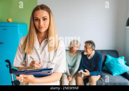 Porträt einer lächelnden kaukasischen Krankenschwester bei einem Hausbesuch mit älterem Paar Stockfoto