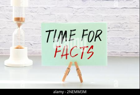 Geschäftskonzept. Auf dem Tisch befinden sich Berichtstabellen, ein Stift, in einem Heftpapier mit der Aufschrift "Time for Facts". Stockfoto