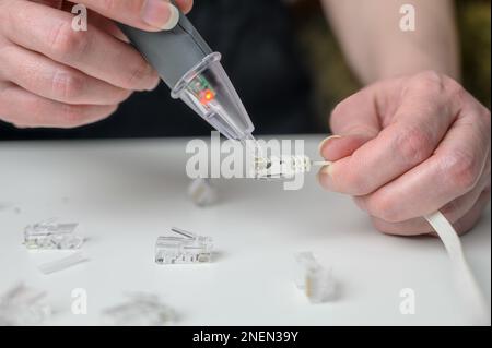 Ein Techniker des Kommunikationssystems prüft das Signal auf einer Datenleitung. Internetsignal und Verkabelung. Stockfoto