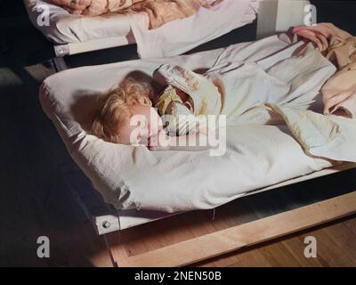 Landwirtschaftsarbeiter-Kind schläft bei 24-Stunden-Kindertagesstätte, Osceola Migratory Labor Camp, Belle Glade, Florida, Marion Post Wolcott, USA Farm Security Administration, Februar 1941 Stockfoto