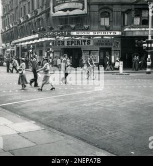 London, England. 1953. Blick auf das Hippodrome-Theater im Londoner West End von der Kreuzung Charing Cross Road und Cranbourn Street. Das Theater zeigt die Revue-Show „High Spirits“ mit Diana Churchill und Cyril Ritchard. Neben dem Theater befindet sich die U-Bahn-Station Leicester Square. Stockfoto