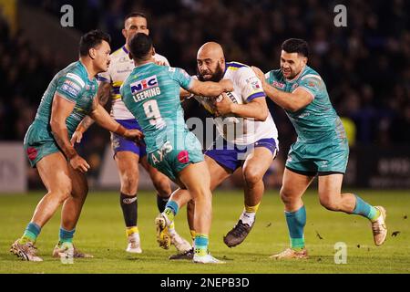 Warrington Wolves Sam Kasiano (Centre) wird während des Spiels der Betfred Super League im Halliwell Jones Stadium in Warrington von Leeds Rhinos' Kruise Leeming (Centre) und Rhyse Martin (Right) angegriffen. Foto: Donnerstag, 16. Februar 2023. Stockfoto