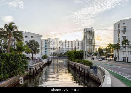 South Beach, Miami am Abend Sonnenuntergang mit Ferienwohnungen in Florida mit tropischen Palmen und Intracoastal Kanalwasser auf der Straße Stockfoto