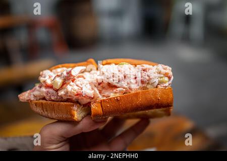 Maine Hummerbrötchen-Sandwich in Brioche Brötchen im Meeresfrüchte-Restaurant Café in Key West, Florida, mit handgehaltener Makro-Nahaufnahme Stockfoto