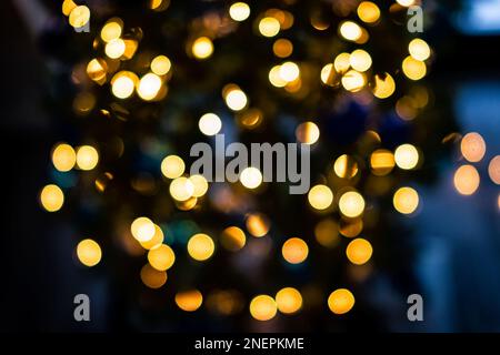 Blaue und goldgelbe Bokeh-Kreise aus Neujahrsweihnachtslicht mit unscharfer Sicht bei Nacht Stockfoto