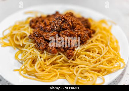 Marinara mit roten Tomaten und Rinderhack-Bolognesesauce und Spaghetti-Nudelgerichte auf weißem Teller Stockfoto