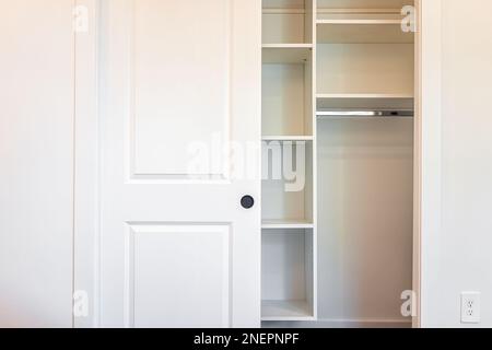 Begehbare Schrankregale mit Schiebetür in modernem minimalistischem weißen Stil mit hellem Licht im Bühnenmodell-Apartment-Schlafzimmer Stockfoto