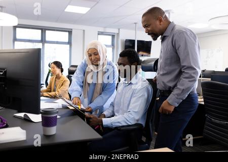 Vielfältige weibliche und männliche Geschäftsleute, die im Büro arbeiten Stockfoto