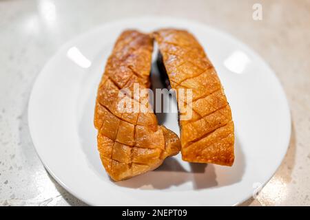 Gekochtes gebackenes Schweinefleisch mit Bauchspeck, mit Bruchkerben auf der Haut, Nahaufnahme des Essens isoliert vor weißem Hintergrund über der Ansicht Stockfoto