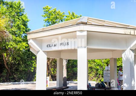 Naples, USA - 8. Dezember 2021: Clam Pass Park Beach-Schild auf der Gartenlaube im Südwesten von Collier County, Florida, mit Menschen, die auf den Shuttlebus warten Stockfoto