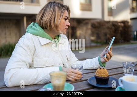 Nahaufnahme des Porträts einer lächelnden blonden Frau mittleren Alters Stockfoto