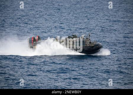 230215-N-AT895-1128 SÜDCHINESISCHE SEE (15. Februar 2023) Ein Landungsschiff, Luftkissen (LCAC) von Assault Craft Unit (ACU) 5, ist neben dem Flugzeugträger USS Nimitz (CVN 68) tätig. Die Nimitz Carrier Strike Group (NIMCSG) und die Makin Island Amphibious Ready Group (MKI ARG), mit der 13. Marineexpeditionstruppen (MEU) in Betrieb genommen werden, führen kombinierte Operationen der Expeditionstruppen (ESF) durch und demonstrieren dabei die einzigartige Kampffähigkeit der Spitzenklasse, die Überlegenheit der Meere, die Machtprojektion und die Bereitschaft. Der Betrieb umfasst integrierte Schulungen zur Verbesserung der Interoperabilität zwischen den beiden Gruppen W. Stockfoto