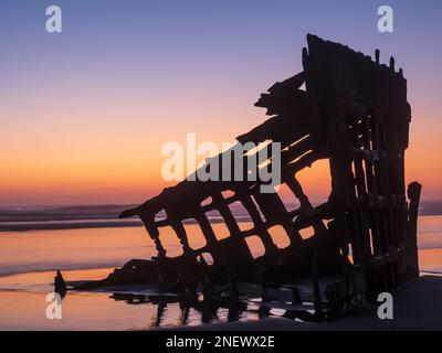 Sonnenuntergang hinter dem Wrack des Peter Iredale von 1906, Fort Stevens State Park, Oregon. Stockfoto