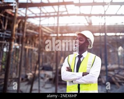 Afrikanische Architekten und Ingenieure mit Schutzhelm arbeiten im Inneren der Baustelle zusammen.Ingenieurkonzepte Stockfoto