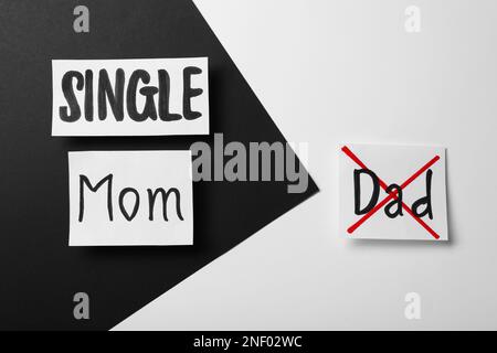 Karten mit Text „Single Mom“ und „Crossed Word Dad“ auf farbigem Hintergrund, flach liegend Stockfoto