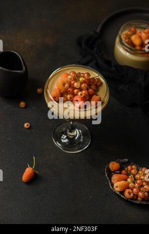 panna Cotta auf dunklem Hintergrund. panna Cotta mit Himbeeren und Johannisbeeren Stockfoto