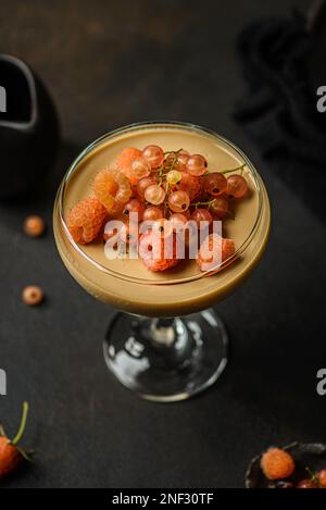 panna Cotta auf dunklem Hintergrund. panna Cotta mit Himbeeren und Johannisbeeren Stockfoto