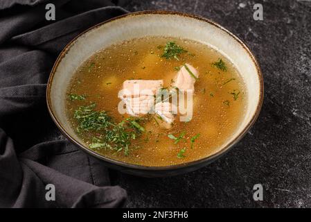 Fischsuppe mit Lachs auf dunklem Hintergrund. Hochwertiges Foto Stockfoto