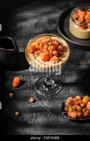 panna Cotta auf dunklem Hintergrund. panna Cotta mit Himbeeren und Johannisbeeren Stockfoto