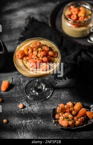 panna Cotta auf dunklem Hintergrund. panna Cotta mit Himbeeren und Johannisbeeren Stockfoto
