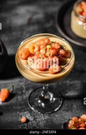 panna Cotta auf dunklem Hintergrund. panna Cotta mit Himbeeren und Johannisbeeren Stockfoto