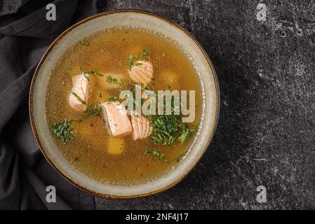 Fischsuppe mit Lachs auf dunklem Hintergrund. Hochwertiges Foto Stockfoto