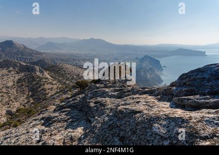 Blick auf Sudak, das Meer, den Berg und den Umhang vom Hang des Berges Falcon Sokol am Morgen im Frühling. Krim Stockfoto