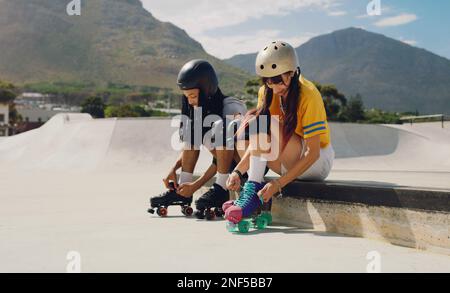 Freunde im Skate-Park, in der Stadt und beim Inlineskaten mit Outdoor-Sportarten, Spaß und bereit zum Skaten in der Stadt mit Helm für Sicherheit. Junger, schwarzer Mann und Stockfoto