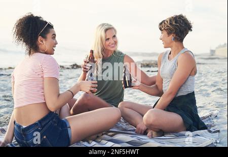 Ich brauche nur einen Drink und meine Freundinnen. Drei Freunde genießen Drinks am Strand. Stockfoto