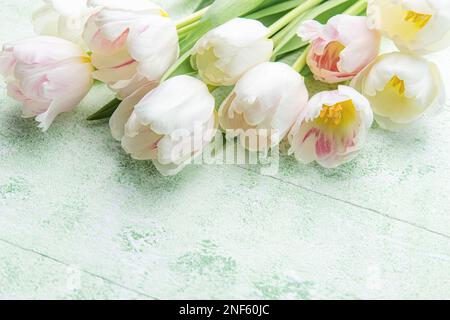 Strauß rosa Tulpen auf grünem Holzhintergrund. Frühlingsferien im Hintergrund. Platz für Text. Flach verlegt. Stockfoto