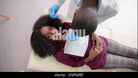 Ein männlicher Zahnarzt Behandlung der Zähne von jungen schwangeren Frau Patient in der Klinik Stockfoto