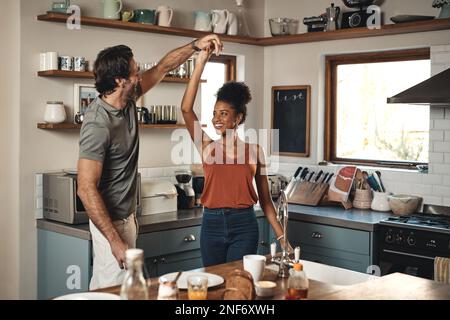 Ich danke dem Himmel, dass du mich geschickt hast. Ein liebevolles junges Paar, das zu Hause in der Küche tanzt. Stockfoto