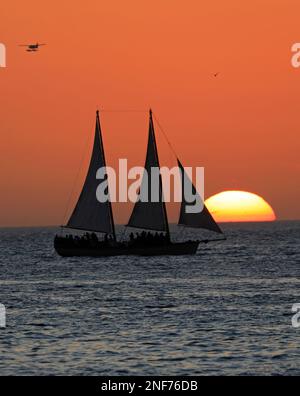 Key West Sonnenuntergang, Golf von Mexiko mit Sonne und Yacht im Hintergrund Stockfoto