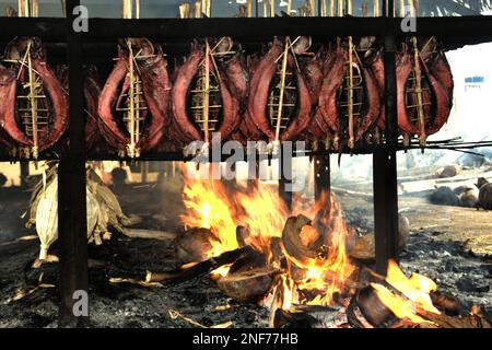 Echtes Thunfischfleisch wird in einer einheimischen Industrie in Bitung, Nord-Sulawesi, Indonesien, mit Kokosspelzen als Brennstoff geräuchert. Der geräucherte Thunfisch wird von einem Forscherteam unter der Leitung von Henny A. Dien (Fakultät für Fischerei und Meereswissenschaften, Sam Ratulangi University, Manado) in seinem ersten Aufsatz, der im Januar 2020 auf Media Teknologi Hasil Perikanan veröffentlicht wurde, als „exotische einheimische Nahrung“ bezeichnet. Die Erzeugung von echtem Thunfisch ist eine der wichtigsten Wirtschaftstätigkeiten in der Region Bitung City, einem der äußeren Ringe der Fischereihäfen Indonesiens, die vor uns liegen. Stockfoto
