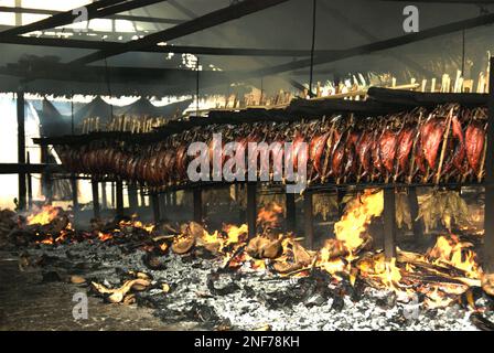 Echtes Thunfischfleisch wird in einer einheimischen Industrie in Bitung, Nord-Sulawesi, Indonesien, mit Kokosspelzen als Brennstoff geräuchert. Der geräucherte Thunfisch wird von einem Forscherteam unter der Leitung von Henny A. Dien (Fakultät für Fischerei und Meereswissenschaften, Sam Ratulangi University, Manado) in seinem ersten Aufsatz, der im Januar 2020 auf Media Teknologi Hasil Perikanan veröffentlicht wurde, als „exotische einheimische Nahrung“ bezeichnet. Die Erzeugung von echtem Thunfisch ist eine der wichtigsten Wirtschaftstätigkeiten in der Region Bitung City, einem der äußeren Ringe der Fischereihäfen Indonesiens, die vor uns liegen. Stockfoto