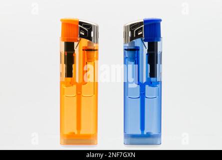 Blaue und orangefarbene Feuerzeuge isoliert auf weißem Hintergrund. Stockfoto