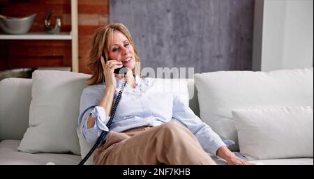 Seniorin Alte, Die Am Festnetztelefon Spricht Stockfoto