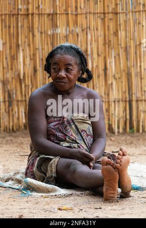 Bekopaka, Madagaskar - November 5. 2022: Ältere madagassische Frau, die sich vor der Hütte entspannt, es gibt hier keine Jobmöglichkeit. Das Alltagsleben auf den Madagas Stockfoto