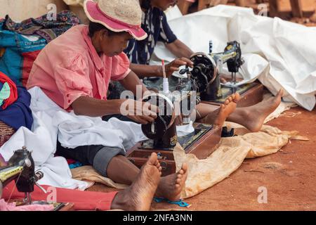 Mandoto, Madagaskar - 9. November. 2022: Straßenschneider und Näherinnen arbeiten mit ihren veralteten Nähmaschinen. Verdiene etwas Geld in Madagaskar ist V Stockfoto